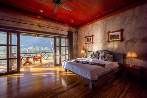 Ban Ngoy-NuaResort Maison de nongkhiaw的一间带大床的卧室和一个阳台