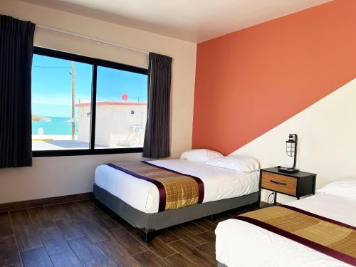圣费利佩Stella del Mar的一间卧室设有两张床和大窗户