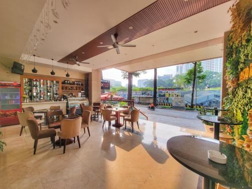 胡志明市雅集西贡酒店的餐厅设有桌椅和大窗户。