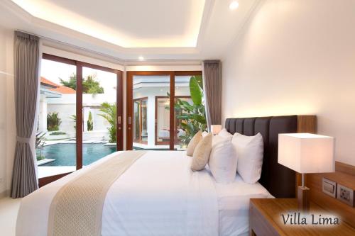 塞米亚克Villa Mia Seminyak - Boutique Villas的卧室设有白色的床和大窗户