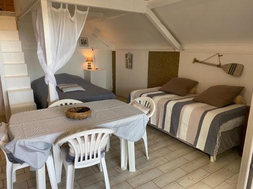 拉萨尔勒班Bungalow Paille en queue sur la plage de La Saline的一间卧室配有两张床和一张桌子及椅子