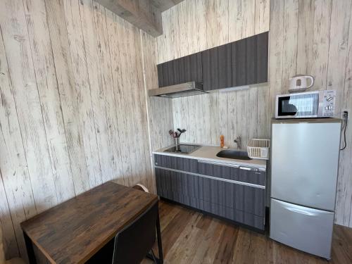 大阪WOLF PACK apartment 1002的厨房铺有木地板,配有白色冰箱。