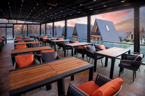 拉戈代希Reserve Resort Lagodekhi的餐厅设有木桌、椅子和窗户。