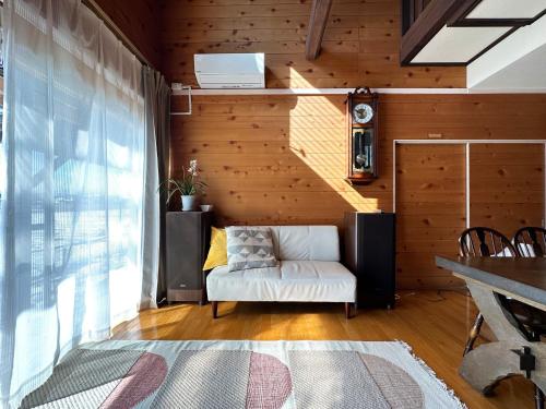 高岛市guest house Kuu - Vacation STAY 46399v的客厅设有白色沙发和木墙