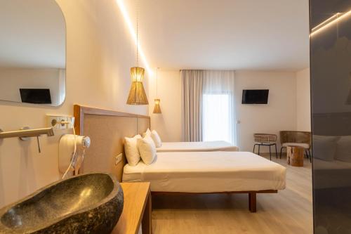 伊维萨镇Play Hotel Ibiza - Adults Only的酒店客房设有两张床和浴缸。
