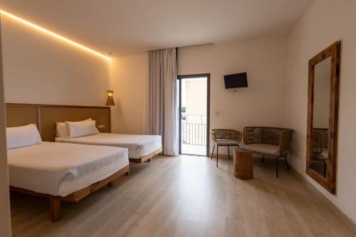 伊维萨镇Play Hotel Ibiza - Adults Only的酒店客房设有两张床和一个阳台。
