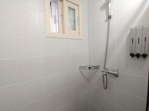 济州市Eutteum-won Pension的带淋浴的浴室和窗户