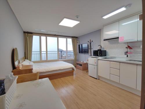 济州市Eutteum-won Pension的一间卧室配有一张床,厨房配有水槽