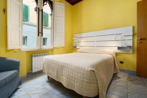 锡耶纳19 Lodge的黄色客房内的一间卧室配有一张大床