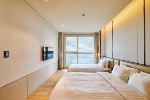 束草市Sono Felice Delpino的酒店客房设有两张床和窗户。