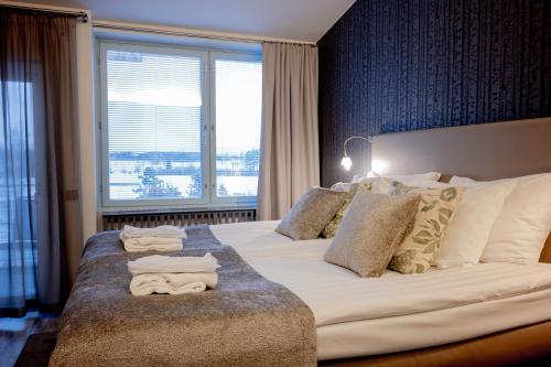 伊卡利宁Ikaalinen SPA & Resort的一间卧室配有一张大床和毛巾