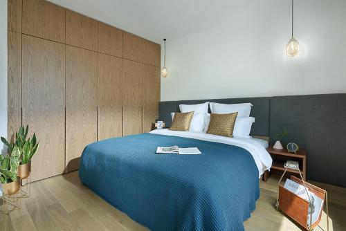 上海basePLUS佰舍服务式公寓(上海滨江店)的一间卧室配有一张带蓝色毯子的大床