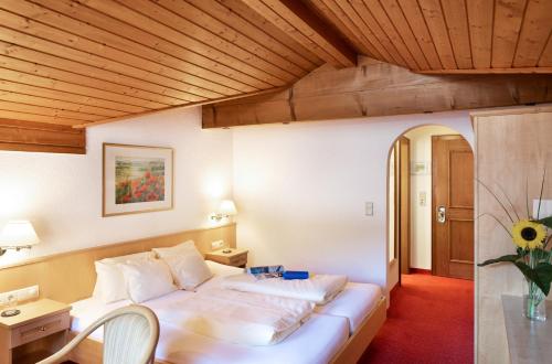 施伦斯津巴酒店的卧室配有一张白色大床和木制天花板