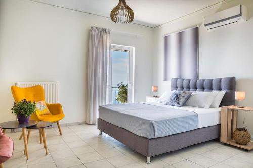 凯法利尼亚岛Cactus Apartment的一间卧室配有一张大床和一张黄色椅子