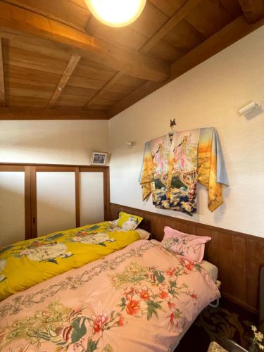 KinugasaKyoto Wakouan Retro Stay的一间卧室设有两张床,墙上挂着一幅画
