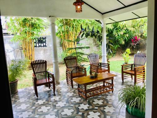 安帕赖Charitha Rest的庭院里摆放着一组椅子和一张桌子