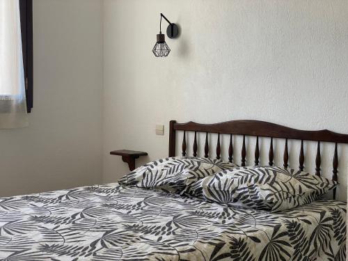 曼德琉-拉纳普勒爱斯特尔汽车旅馆的一张带黑白棉被和枕头的床