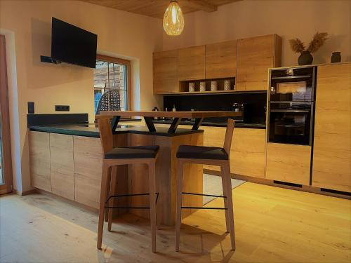 阿亨基希Chalet Tuxer的厨房配有木桌和椅子