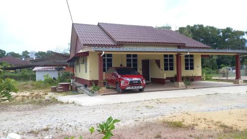 Kampong Wakaf TengahMufeed Homestay的停在房子前面的红色汽车