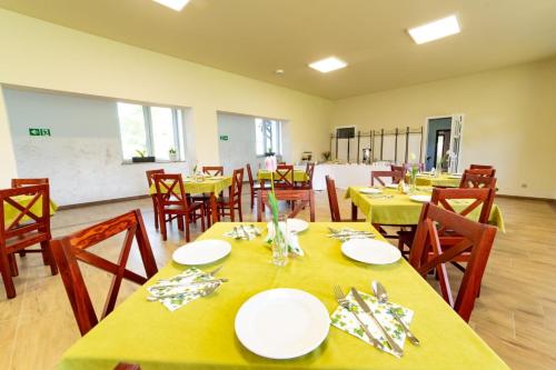 WańkowaHotel BIESZCZADski Wańkowa的用餐室配有黄色桌子和木椅