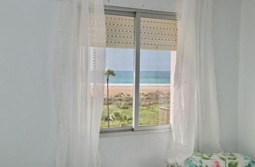 科尼尔-德拉弗龙特拉Apartamento La Fuente的一间卧室设有窗户,享有海滩美景