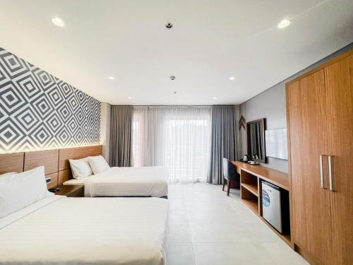 ManaoagThe Manaoag Hotel的酒店客房设有两张床和电视。