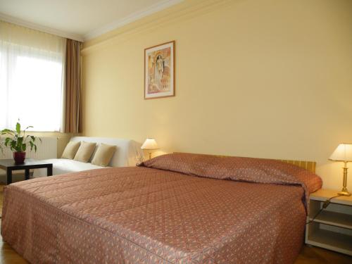 布达佩斯布达佩斯布达公寓式酒店的酒店客房,配有床和沙发