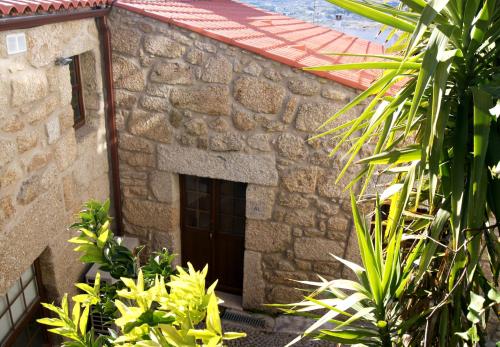 贝尔蒙特Cantinho Santiago的石头建筑,有门和一些植物
