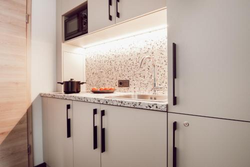 丁戈尔芬ADEBAR Stadthotel的厨房配有白色橱柜和水槽