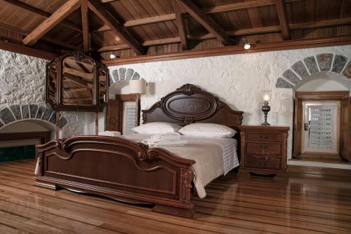 伊兹拉Mansion Eugenie的一间卧室设有一张大床,铺有木地板