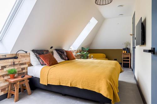 HolthoneB&B De Scheersehoeve的一间卧室配有一张带黄色毯子的大床