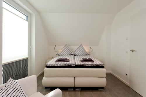 佩讷明德Ferienhäuser im Yachthafen mit Hund的一间白色卧室,卧室内配有一张床