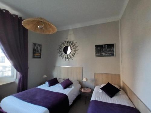 里尔Au Moulin d'Or的一间卧室设有两张床,墙上设有一面镜子