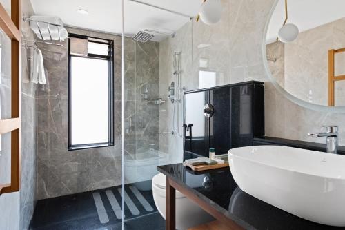 乌提WelcomHeritage Ayatana, Ooty的带浴缸、水槽和镜子的浴室