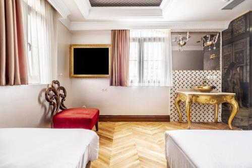 伊斯坦布尔Glamorous Authentic Studio in Üsküdar的客房设有两张床、一张桌子和一台电视机。