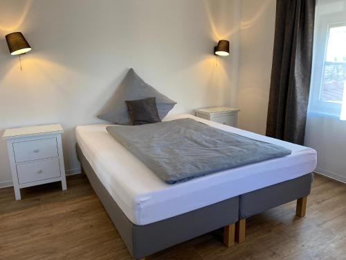 KünzingVilla Quintana的卧室内的一张床位,配有2个床头柜和2盏灯