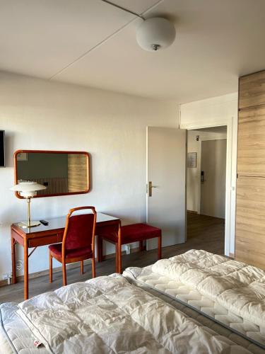 赫尔辛格Marienlyst Apartment的一间卧室配有一张床、一张桌子和一张桌子