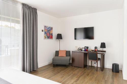 比斯卡罗斯海普酒店的酒店客房配有书桌和电视。