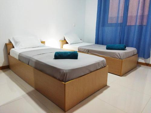 普拉亚Apto Morabeza T2 Praia的配有蓝色窗帘的客房内的两张床