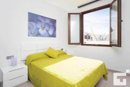 卡尔佩Villa Mirador de Bassetes 4 - Grupo Turis的一间卧室设有黄色的床和窗户。