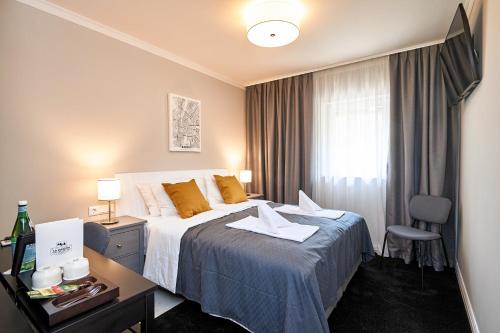 La Maison的配有一张床、一张书桌和一扇窗户的酒店客房