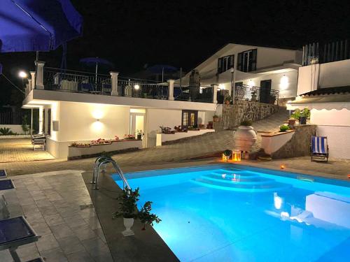 圣塔马里亚迪卡斯特Serra Marina Rooms and Apartments的夜间在房子前面的游泳池