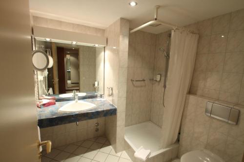马格德堡热特斯瓦格酒店的一间带水槽、淋浴和卫生间的浴室