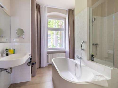 柏林Schoenhouse Avenue - Digital Access的带浴缸、水槽和窗户的浴室