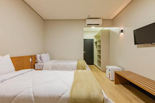 安东尼奥帕拉多Tri Hotel Antônio Prado的一间酒店客房,设有两张床和电视
