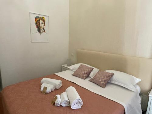 卡塔尼亚Sleep Inn Catania rooms - Affittacamere的一张带毛巾的床和一张女人的照片