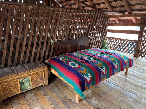 SchiuleştiCasa de vacanta traditionala La Fanar的一张带五颜六色的被子的床