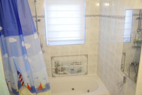 贡特拉姆斯多夫100qm comfort, family-friendly and top located的一间带浴缸和淋浴的浴室,并设有一个窗户