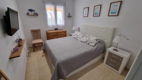 维拉casa luxury 2 nudista的一间小卧室,配有一张床和电视