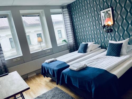 哥德堡太乐床和早餐哥德堡城大酒店的一间卧室设有两张床和两个窗户。
